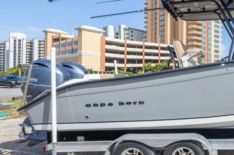 Slide: The Image of 2018 Cape Horn 27XS boat on trailer, parked near modern buildings. - 20