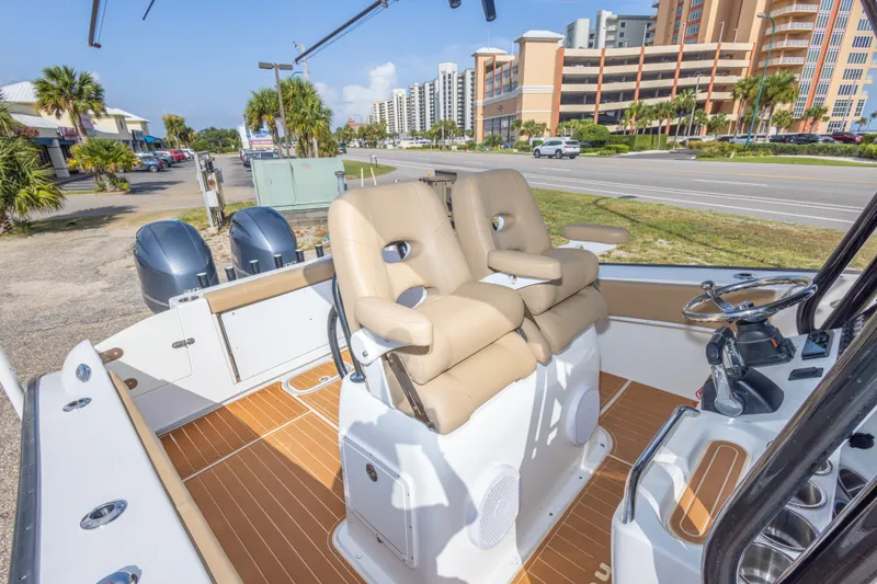 Slide: The Image of 2018 Cape Horn 27XS boat interior with dual seats and twin engines, near a coastal road. - 39