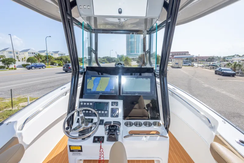 Slide: The Image of 2018 Cape Horn 27XS boat dashboard with navigation screens and steering wheel. - 27