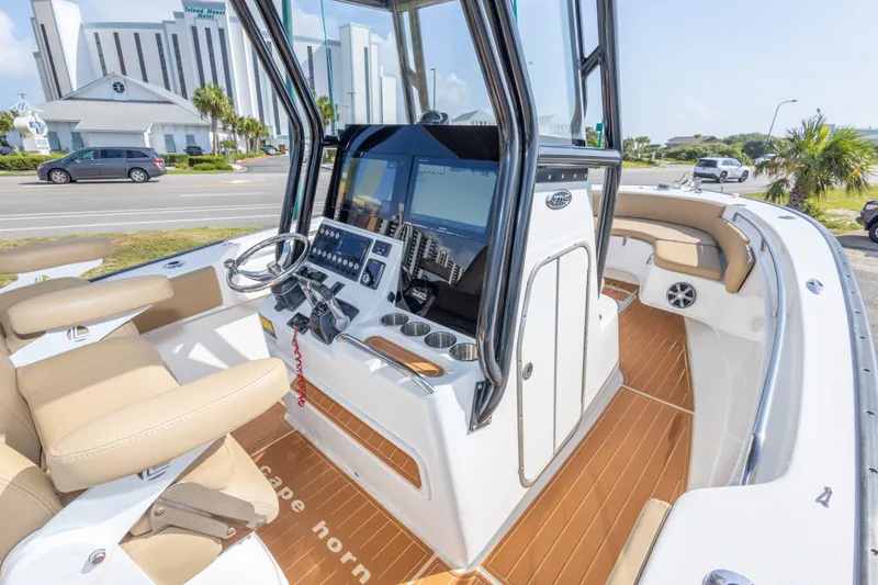 Slide: The Image of 2018 Cape Horn 27XS boat interior with modern helm, beige seating, and wood-style flooring. - 26