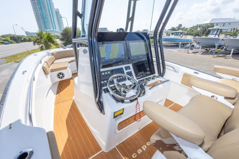 Slide: The Image of 2018 Cape Horn 27XS boat interior with modern helm, dual screens, and tan seating. - 25