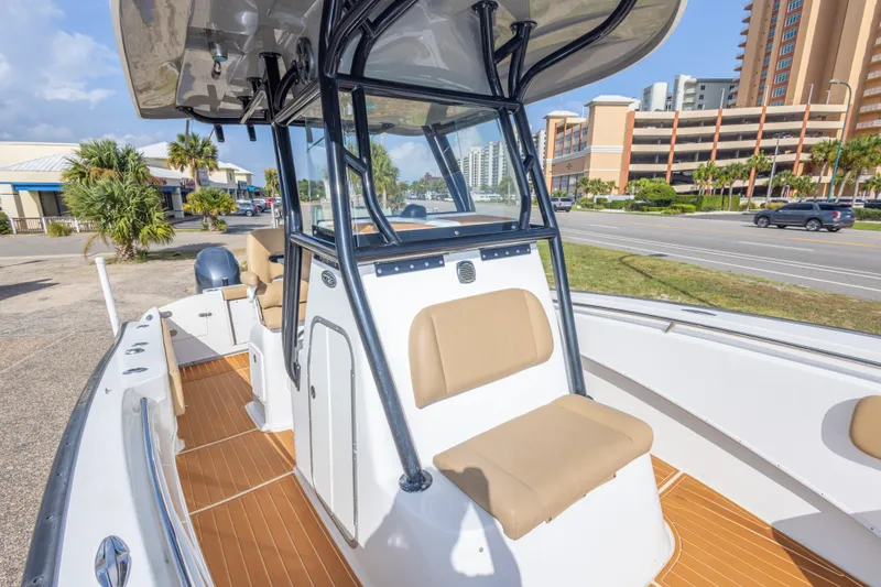 Slide: The Image of 2018 Cape Horn 27XS boat with tan seating, docked near a road and buildings. - 36