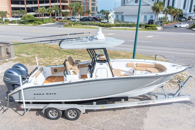 Slide: The Image of 2018 Cape Horn 27XS boat on trailer, parked near a road with buildings in the background. - 3