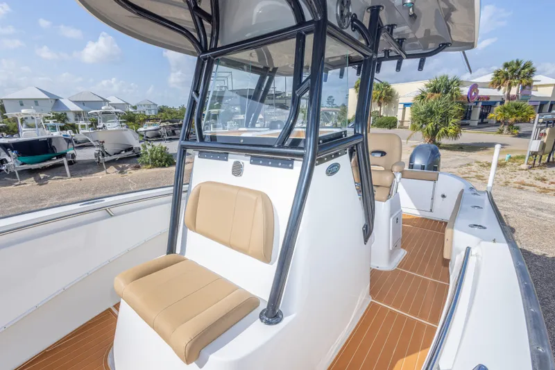 Slide: The Image of 2018 Cape Horn 27XS boat with tan seating, docked in a marina under a clear sky. - 37