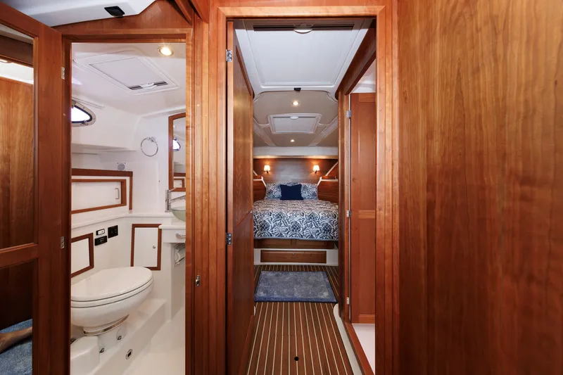 Slide: The Image of 2020 Back Cove 41 yacht interior with wooden finish, featuring a cozy bedroom and bathroom. - 23