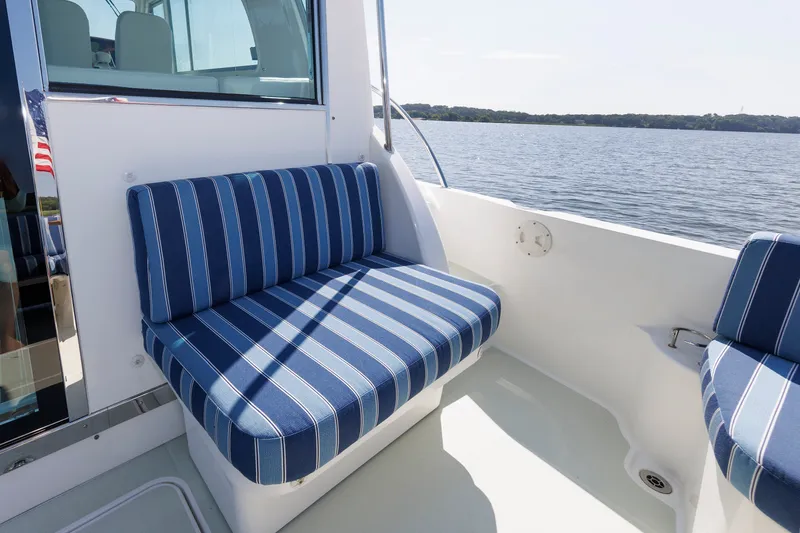 Slide: The Image of Blue striped seating on 2020 Back Cove 41 boat deck, overlooking calm waters. - 38