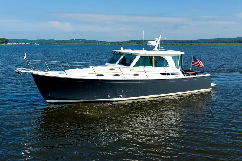 Slide: The Image of 2020 Back Cove 41 yacht cruising on a serene lake under a clear blue sky. - 5