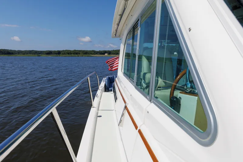 Slide: The Image of 2020 Back Cove 41 yacht cruising on a serene lake with American flag. - 45