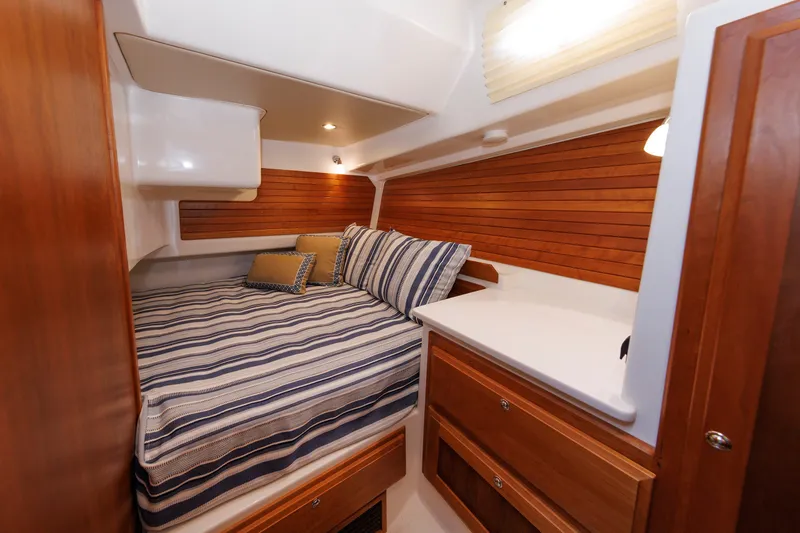 Slide: The Image of Cozy cabin interior of 2020 Back Cove 41 yacht with striped bedding and wooden accents. - 25