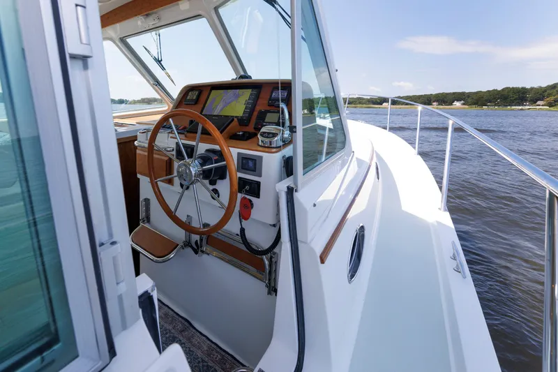 Slide: The Image of 2020 Back Cove 41 yacht helm with wooden steering wheel and navigation equipment on a sunny day. - 46