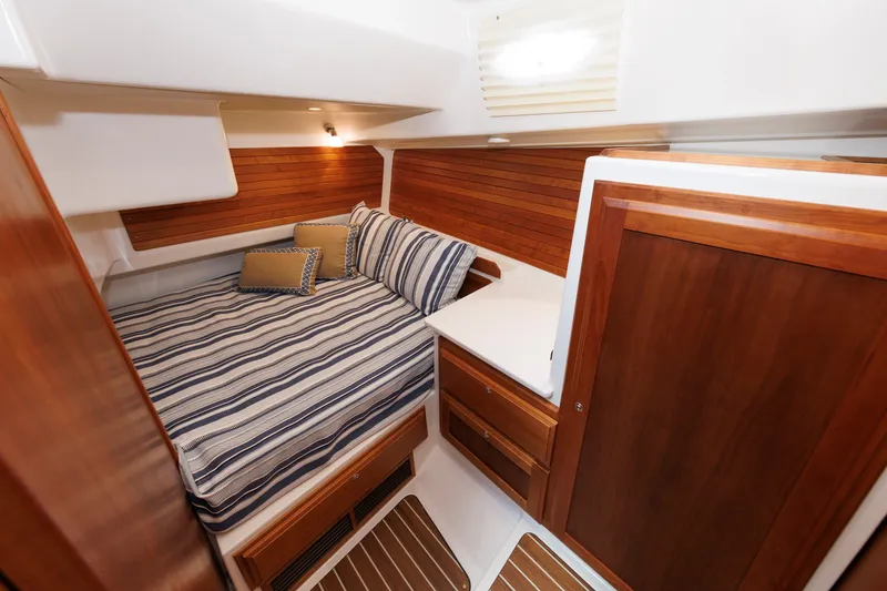Slide: The Image of Luxurious cabin interior of 2020 Back Cove 41 yacht with striped bedding and wooden accents. - 24