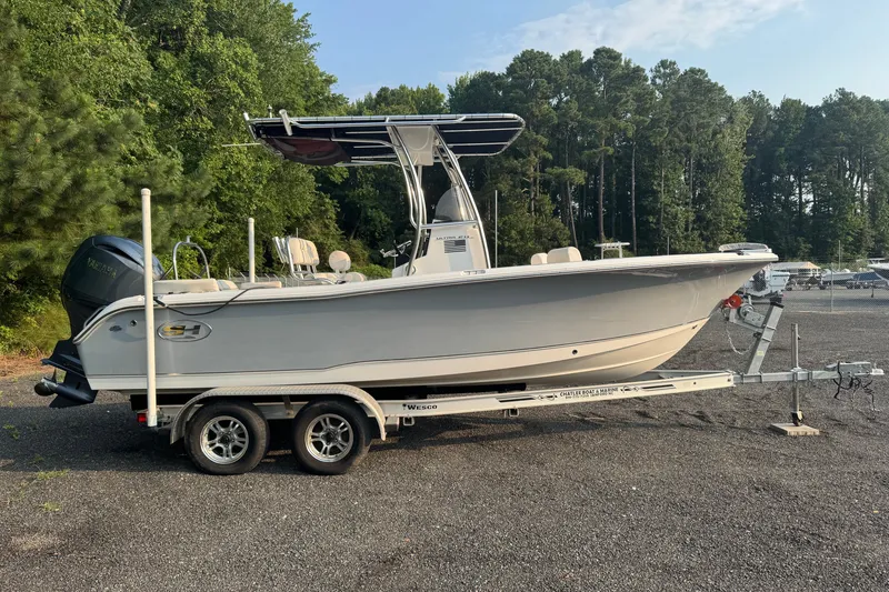 Slide: The Image of 2020 Sea Hunt Ultra 211 boat on trailer, parked outdoors near trees. - 1