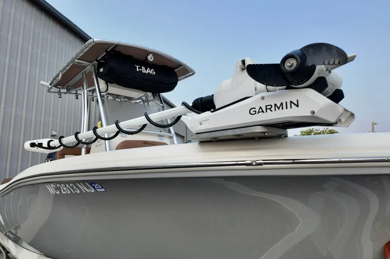Slide: The Image of 2025 Pioneer 202 Sportfish boat with Garmin equipment, docked near a metal building. - 3