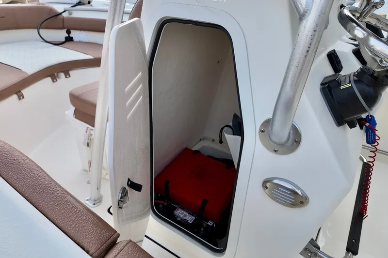Slide: The Image of 2025 Pioneer 202 Sportfish boat storage compartment with open door, revealing interior equipment. - 10