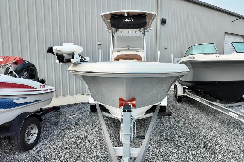Slide: The Image of 2025 Pioneer 202 Sportfish boat on trailer, parked between two other boats. - 4