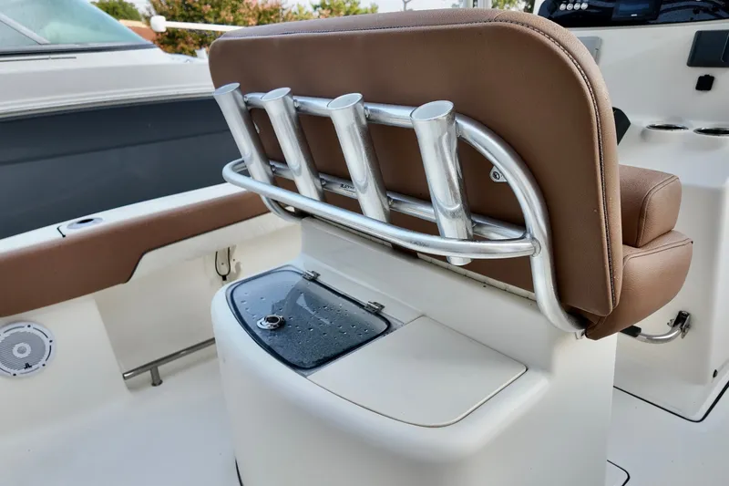 Slide: The Image of 2025 Pioneer 202 Sportfish boat interior with rod holders and cushioned seating. - 16