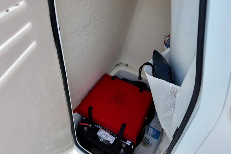 Slide: The Image of Storage compartment in 2025 Pioneer 202 Sportfish boat with red battery and accessories. - 9
