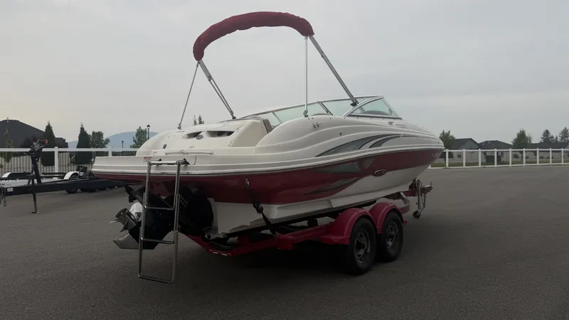 Slide: The Image of A 2004 Sea Ray 200 Sundeck on a trailer, featuring a red hull and bimini top. - 25