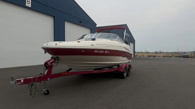 Slide: The Image of A 2004 Sea Ray 200 Sundeck on a trailer in front of a large blue building. - 6