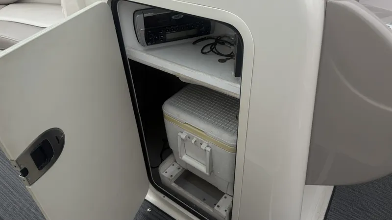 Slide: The Image of An open storage compartment on a boat reveals a radio and a cooler. - 18