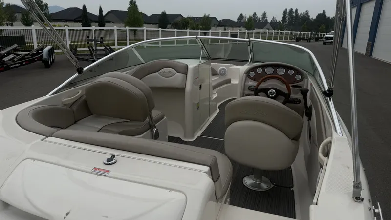 Slide: The Image of The image shows the cockpit of a 2004 Sea Ray 200 Sundeck boat with beige seating. - 9