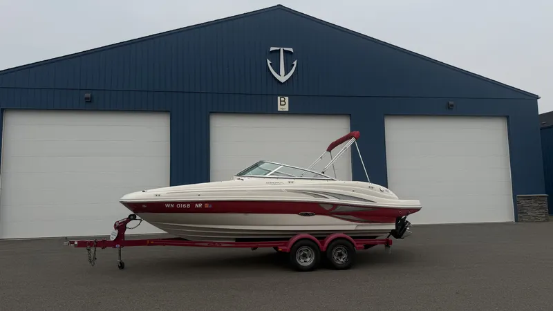 Slide: The Image of A 2004 Sea Ray 200 Sundeck on a trailer in front of a large blue building. - 24