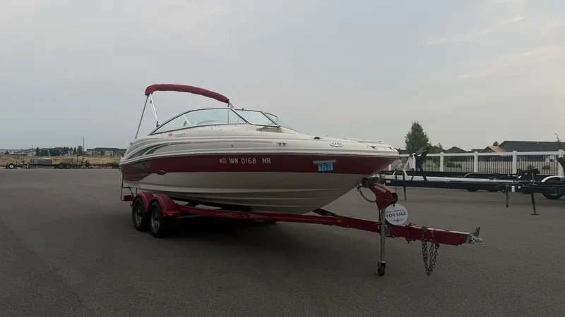 Slide: The Image of A 2004 Sea Ray 200 Sundeck on a red trailer in a parking lot. - 4