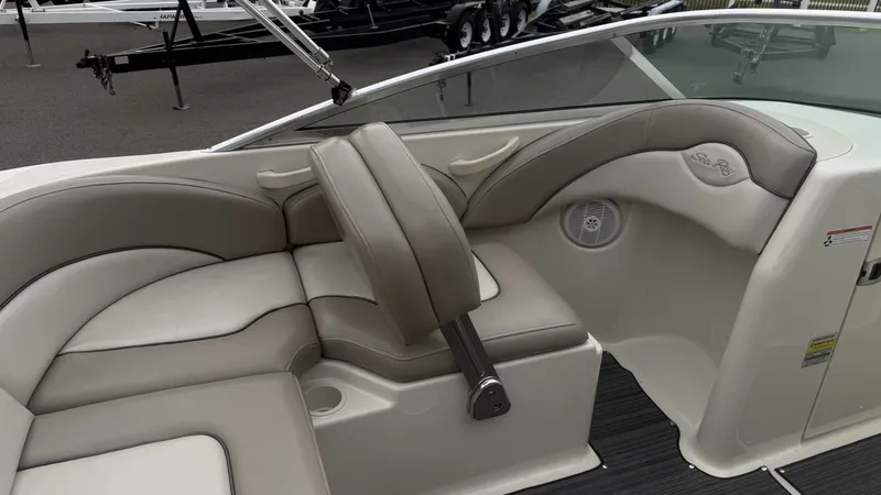 Slide: The Image of Interior of a 2004 Sea Ray 200 Sundeck with beige upholstery and a speaker. - 11