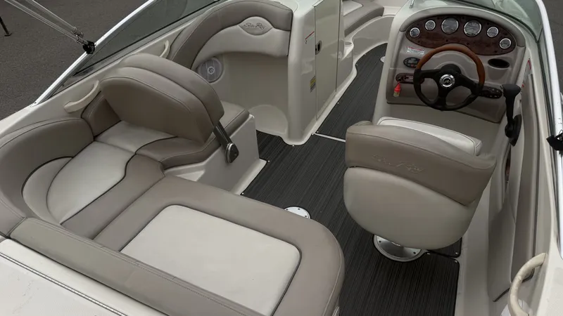 Slide: The Image of The image shows the cockpit of a 2004 Sea Ray 200 Sundeck with beige seating and a sleek dashboard. - 10