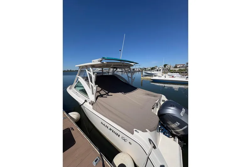 Slide: The Image of 2018 Sailfish 245 DC boat docked with Yamaha 250 engine, clear sky background. - 11