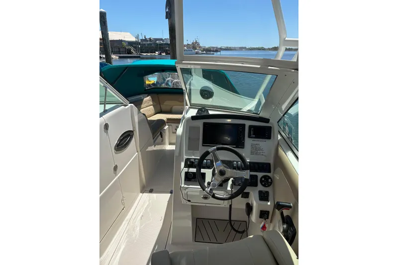 Slide: The Image of 2018 Sailfish 245 DC boat cockpit with steering wheel and navigation controls. - 24