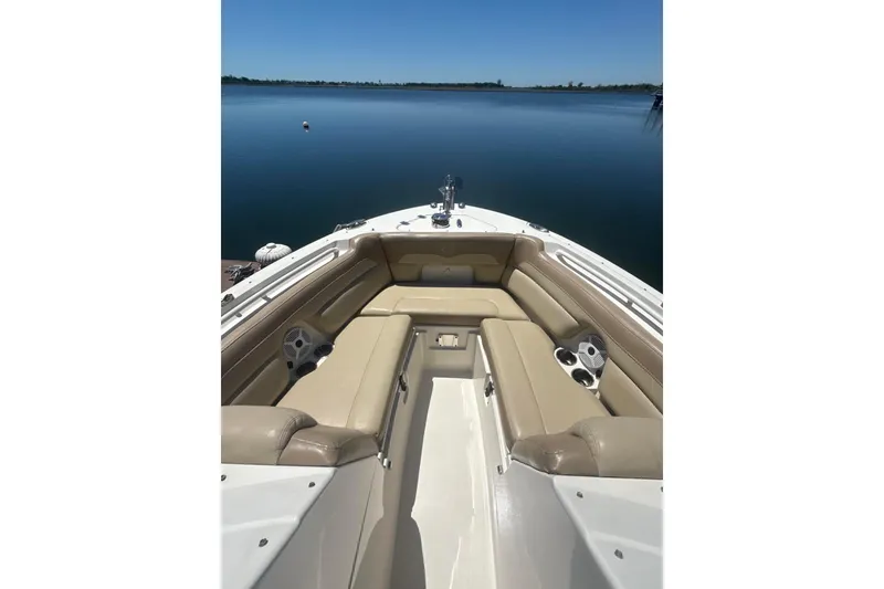 Slide: The Image of 2018 Sailfish 245 DC boat interior with beige seating, on calm water. - 21