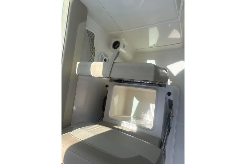 Slide: The Image of 2018 Sailfish 245 DC boat interior with cushioned seating and storage compartment. - 13