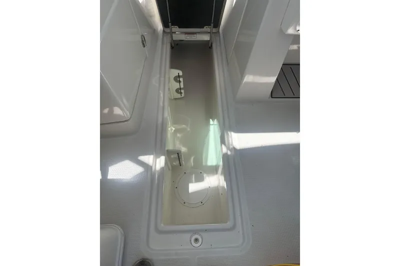 Slide: The Image of 2018 Sailfish 245 DC boat interior storage compartment, featuring clean white surfaces. - 12