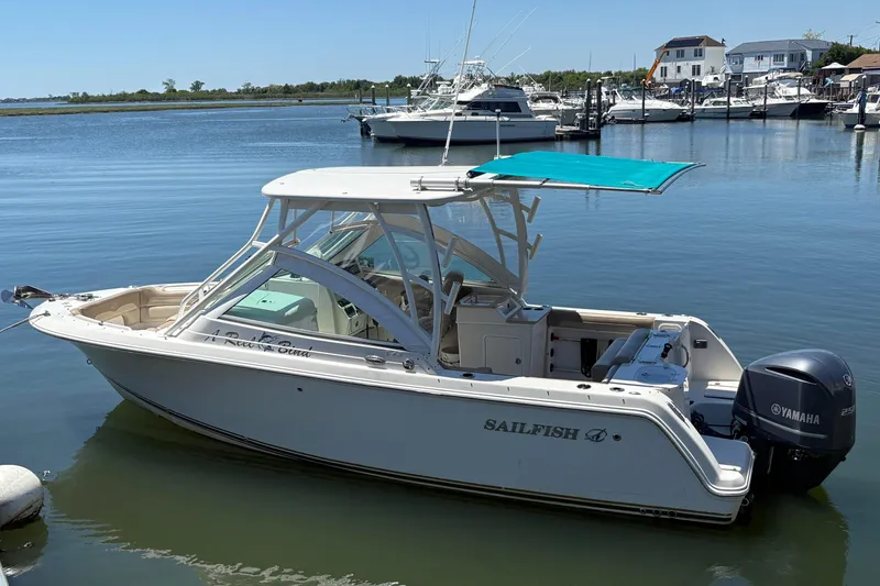The Image of 2018 Sailfish 245 DC boat docked, featuring Yamaha outboard motor and teal canopy. - 1