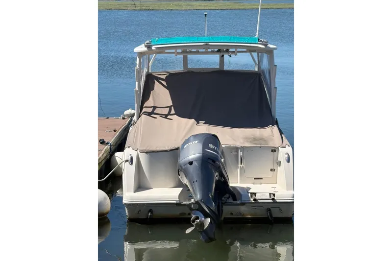 Slide: The Image of 2018 Sailfish 245 DC boat with Yamaha outboard motor, docked on calm water. - 8