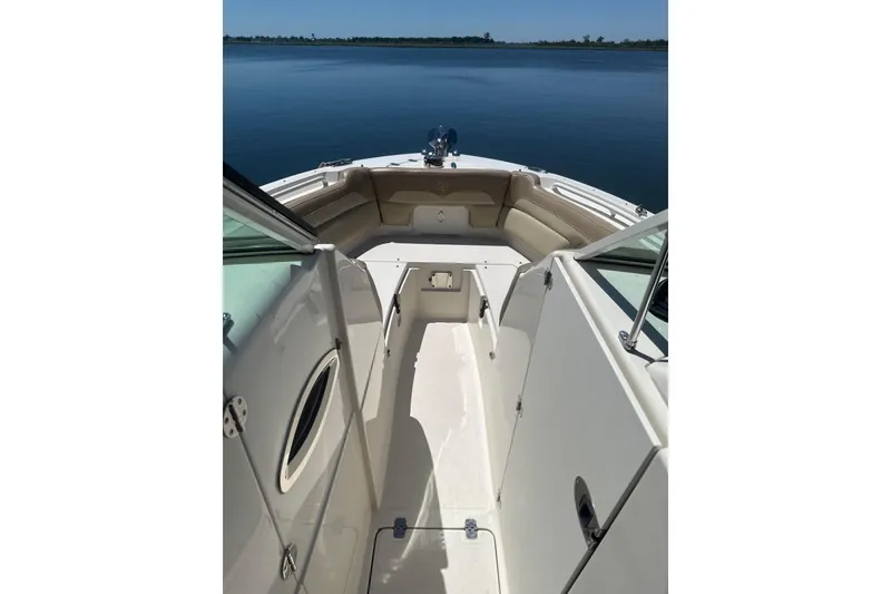 Slide: The Image of 2018 Sailfish 245 DC boat interior with open deck and seating, on calm water. - 20