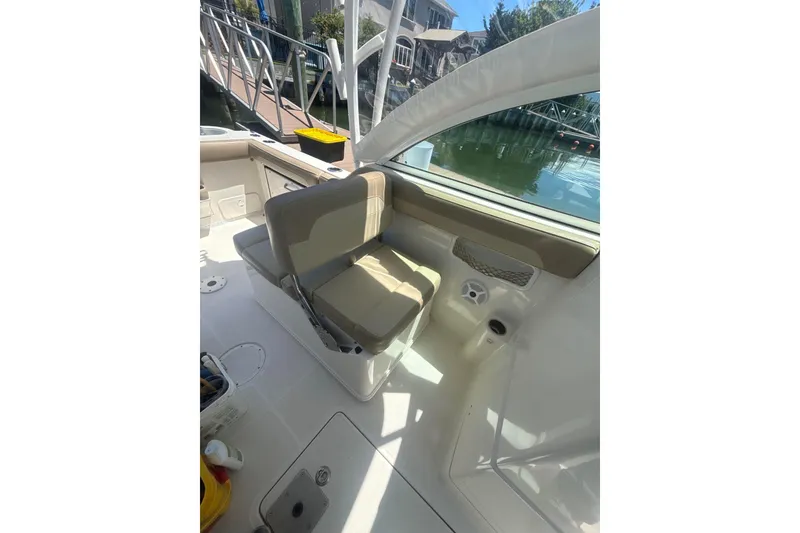Slide: The Image of Interior of a 2018 Sailfish 245 DC boat, featuring comfortable seating and waterfront view. - 16
