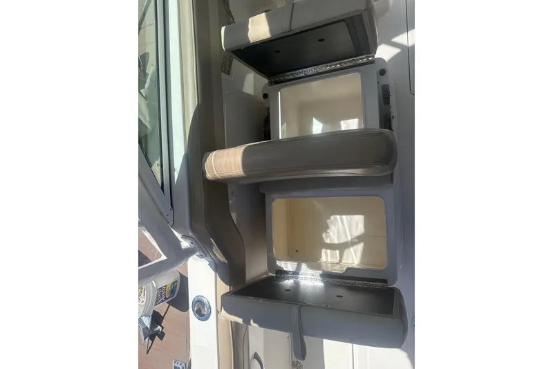 Slide: The Image of 2018 Sailfish 245 DC boat interior with open storage compartments and cushioned seating. - 15