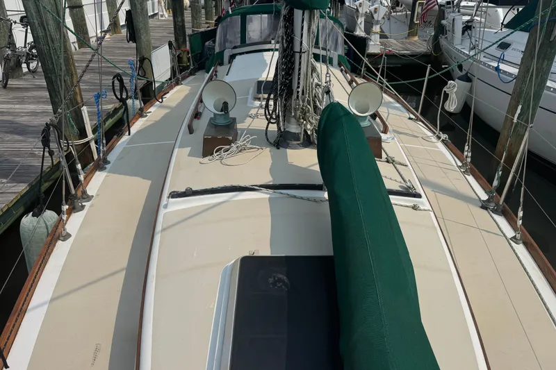 Slide: The Image of 1986 Cape Dory 36 sailboat docked, featuring green covers and classic deck design. - 23