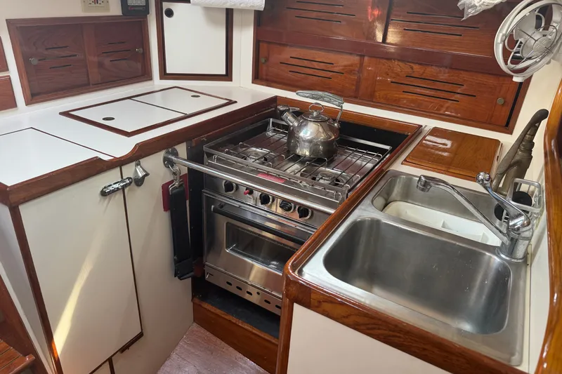Slide: The Image of Galley kitchen in 1986 Cape Dory 36 sailboat with stove, sink, and wooden cabinetry. - 4