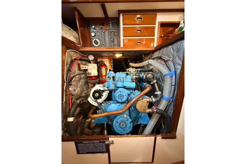 Slide: The Image of Engine compartment of a 1986 Cape Dory 36 sailboat, featuring a blue marine engine. - 17
