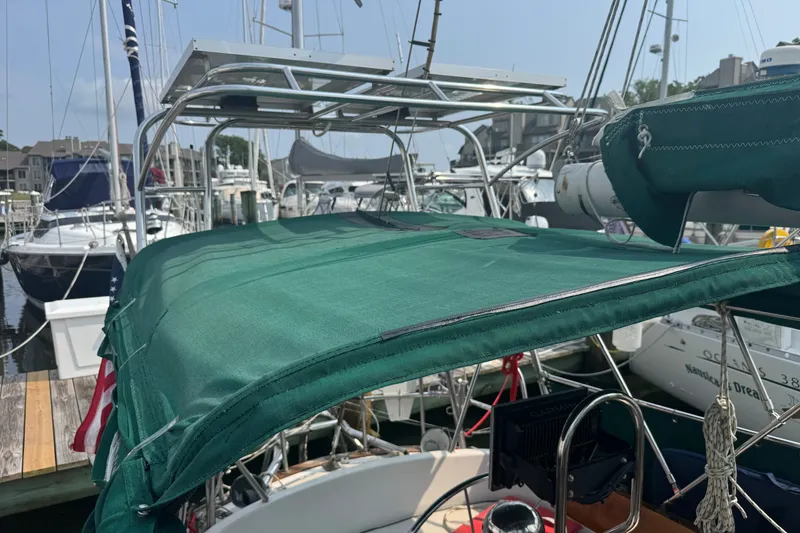 Slide: The Image of 1986 Cape Dory 36 sailboat with green canvas cover docked at marina. - 20