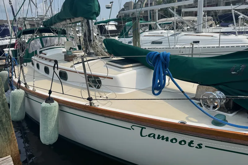 Slide: The Image of 1986 Cape Dory 36 sailboat docked, featuring green covers and classic design elements. - 25