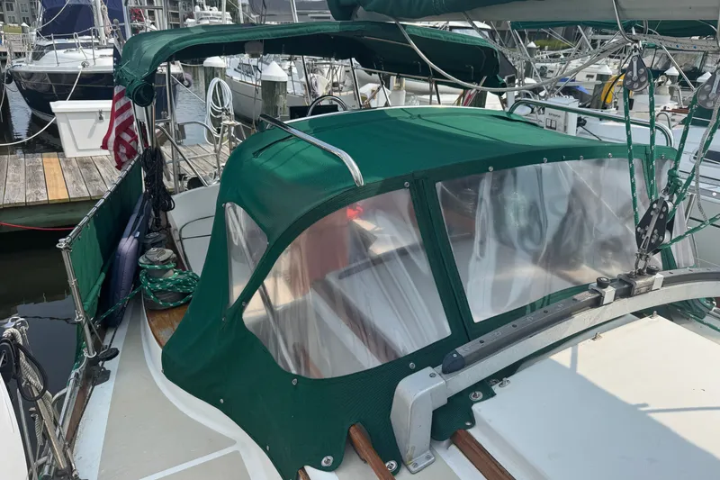 Slide: The Image of 1986 Cape Dory 36 sailboat with green canvas cover docked at marina. - 21