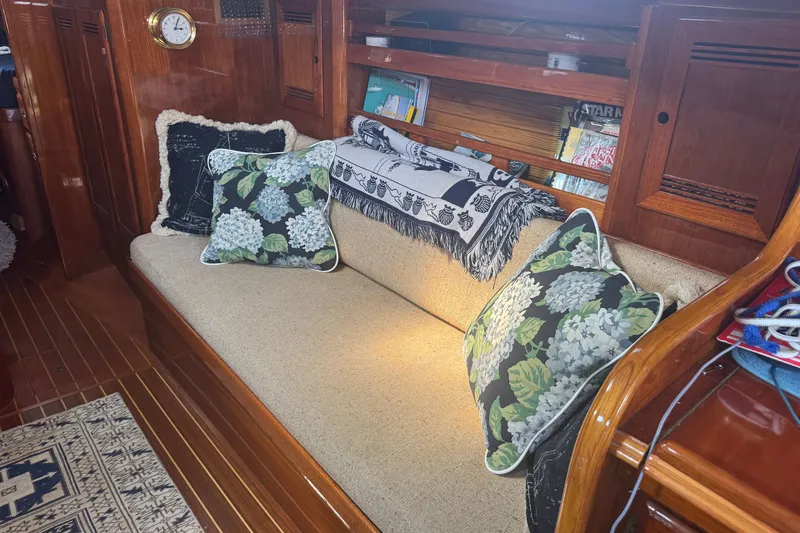 Slide: The Image of Cozy interior of 1986 Cape Dory 36 sailboat with floral cushions and wooden accents. - 12