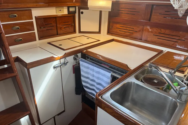Slide: The Image of 1986 Cape Dory 36 yacht kitchen with wooden cabinetry and stainless steel sink. - 4