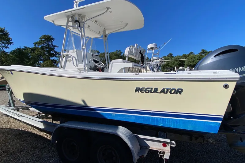 Slide: The Image of 2006 Regulator 23 Forward Seating boat on trailer, featuring Yamaha engine, under clear blue sky. - 2