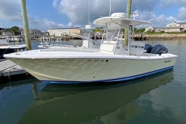 The Image of 2006 Regulator 23 Forward Seating boat docked in a marina under a cloudy sky. - 0