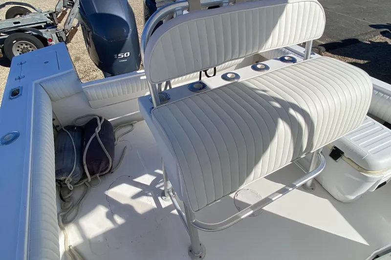 Slide: The Image of 2006 Regulator 23 Forward Seating boat interior with white cushioned seats and Yamaha 150 engine. - 17